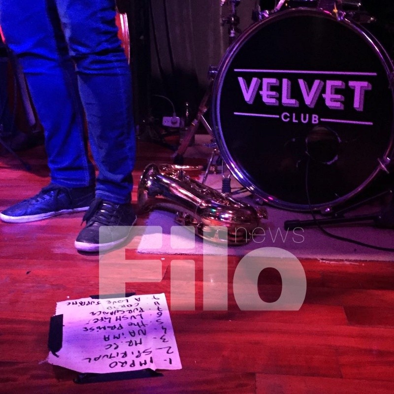 Los pies de Roberto Petinatto junto al saxo y el listado de temas tocados / Foto: Filo News